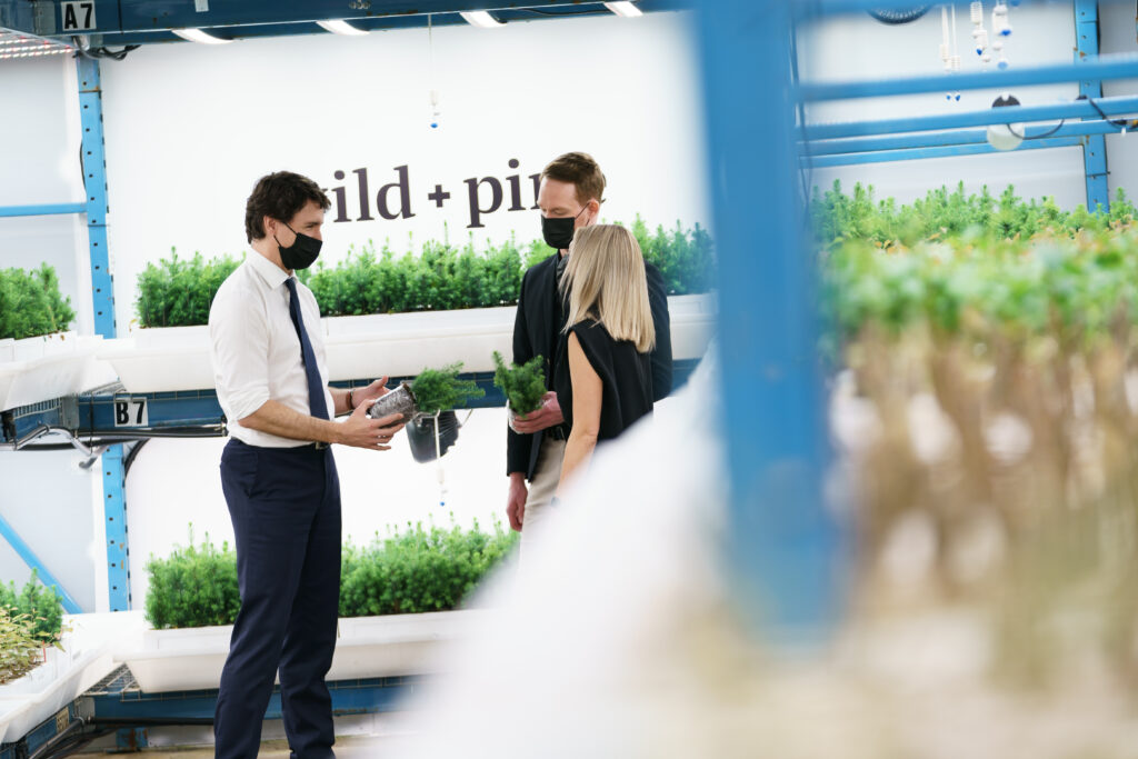 Prime Minister Justin Trudeau holds seedlings in the Wild + Pine greenhouse